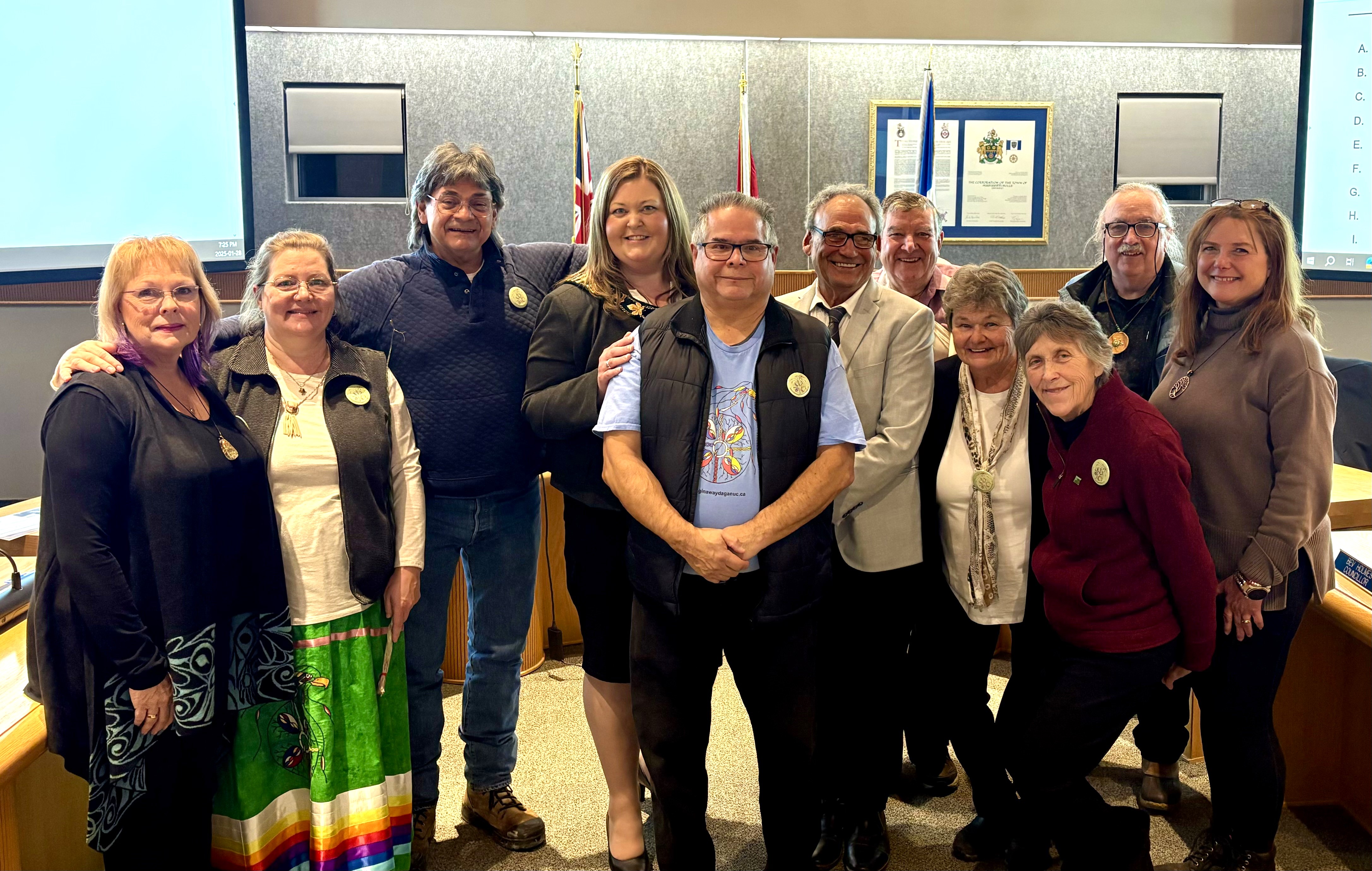 A group of people pose together for a photo inside a room