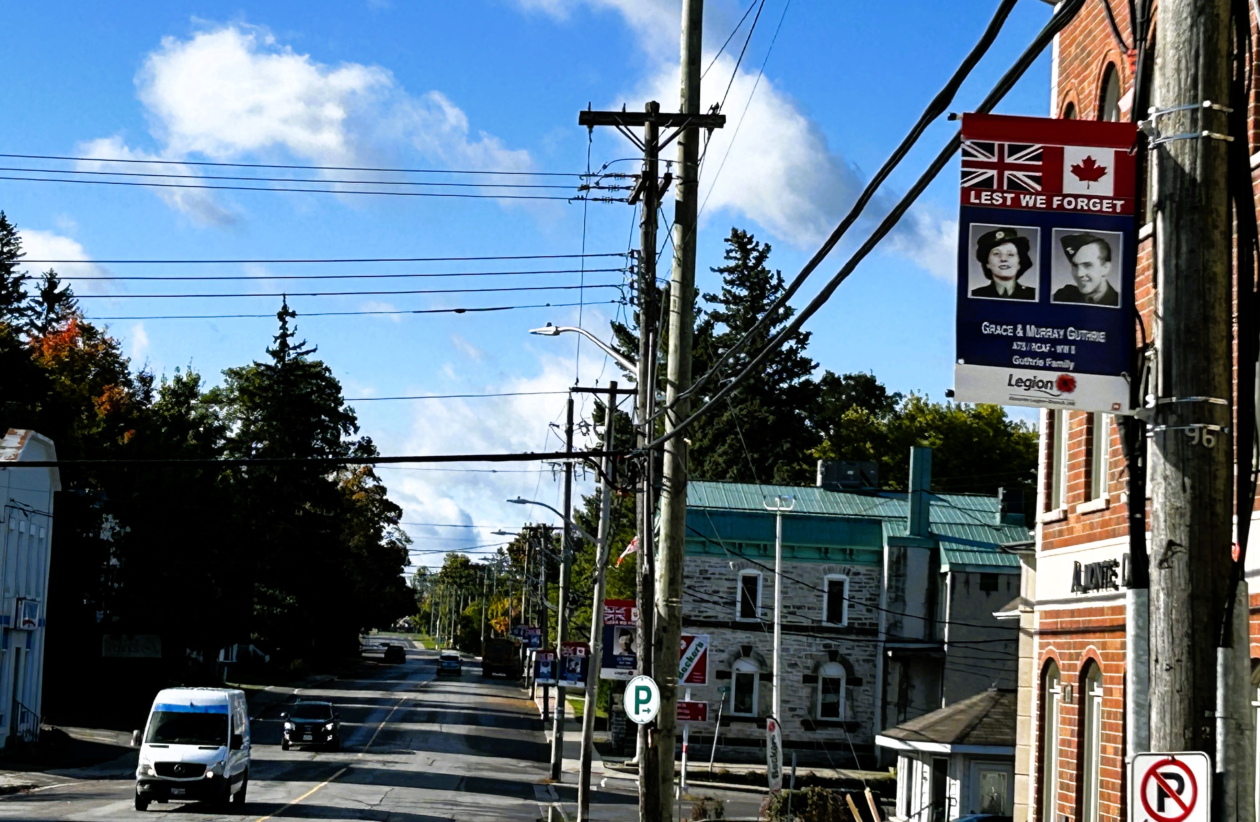 Photo of small town street with banner honouring veterans hanging from a post