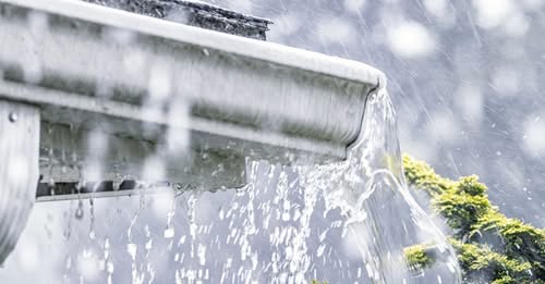 Rain pouring out of white eavestrough