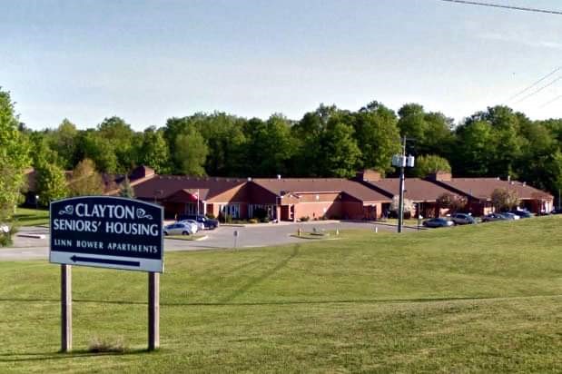 Photo of block of housing with a sign in front reading 'Clayton Seniors' Housing'