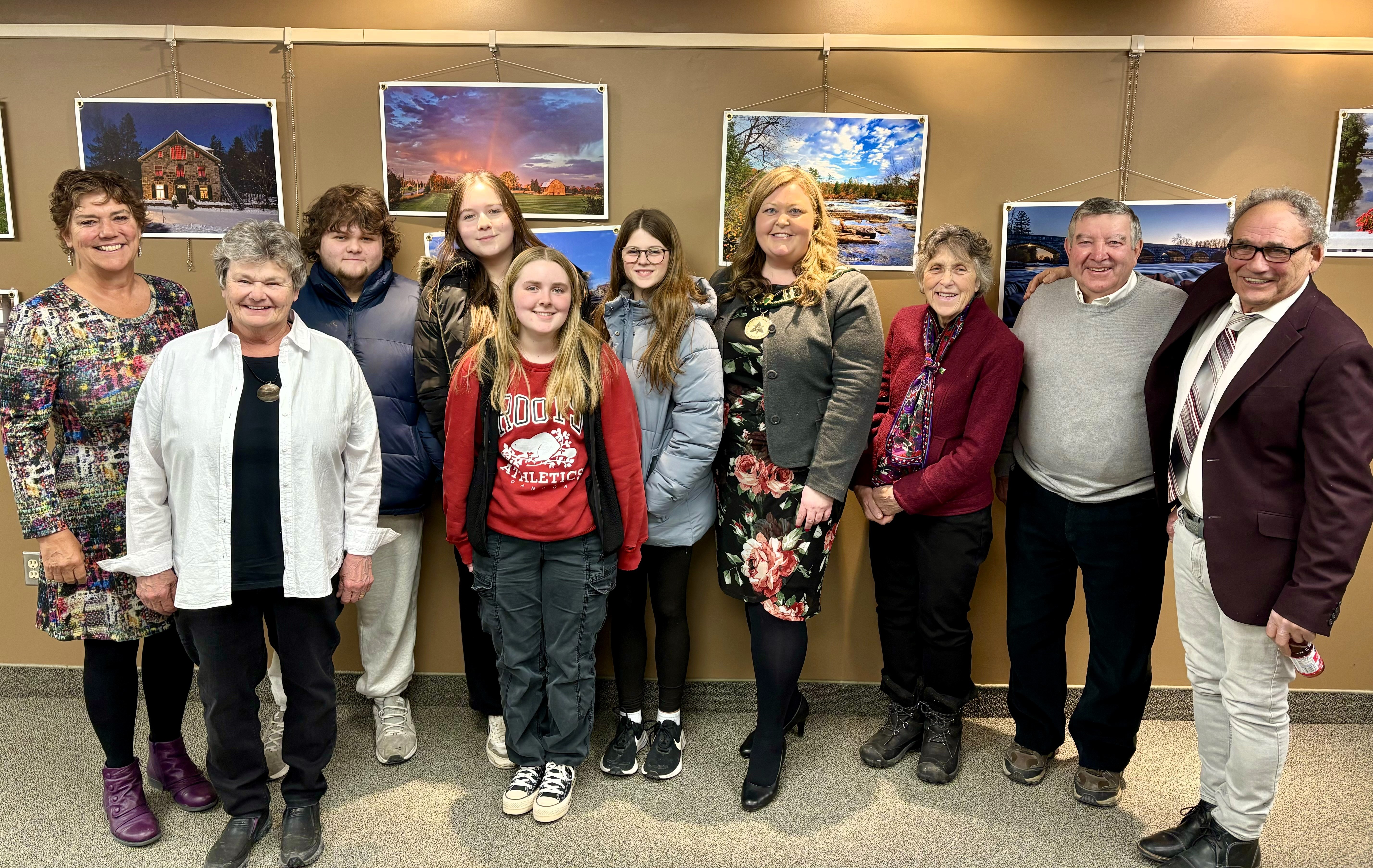 Photo of group in front of a wall of photos