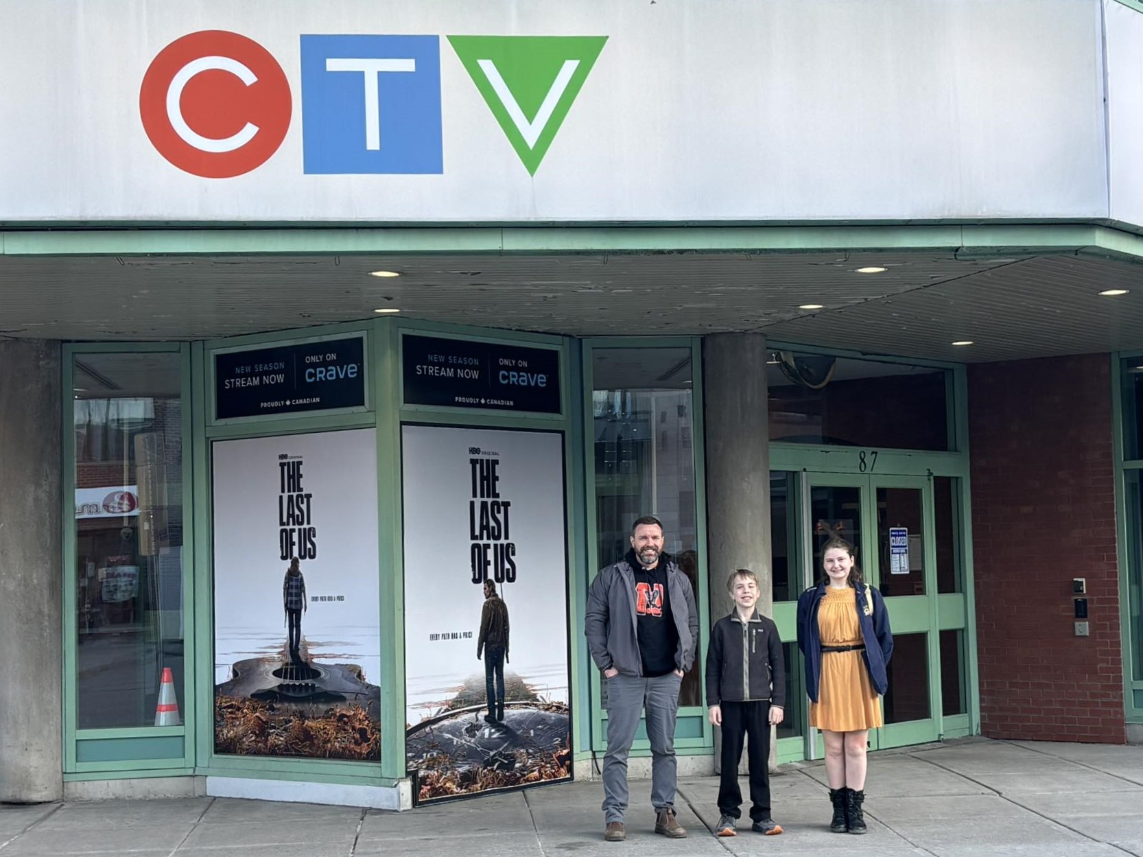 A teacher and two students stand outside CTV Ottawa headquarters
